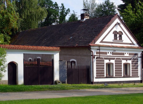 Venkovská chalupa s hnědými okenicemi