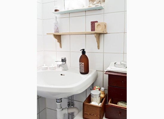 Dřevěné doplňky v bílé skandinávské koupelně