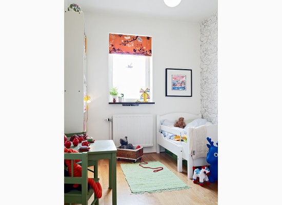 Dětský pokoj s bílou postýlkou a zeleným stolkem