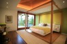 Moderní ložnice s netradiční dřevěnou postelí s nebesy