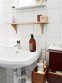 Dřevěné doplňky v bílé skandinávské koupelně