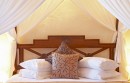 Dřevěná postel s bílými  polštáři