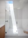 Jednoduchá bílá koupelna plná slunce 