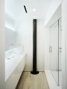 Černý sloup v bílé skandinávské koupelně 